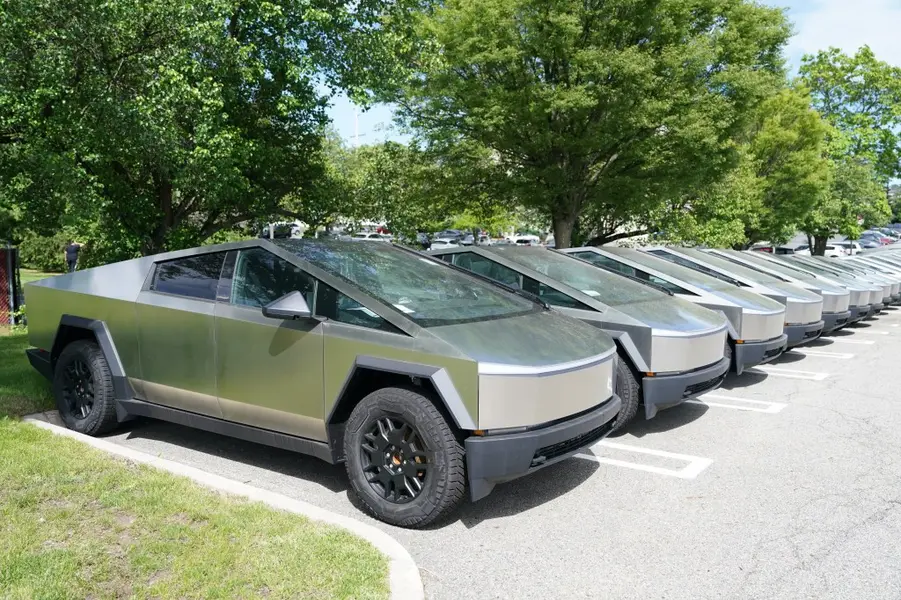 یک ردیف از تسلا سایبرترک‌ها که در یک پارکینگ پارک شده‌اند.