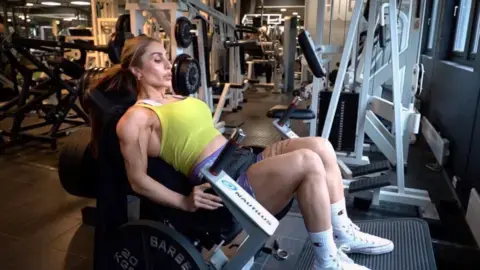 رویا کاریمی نشسته بر یک دستگاه ورزشی