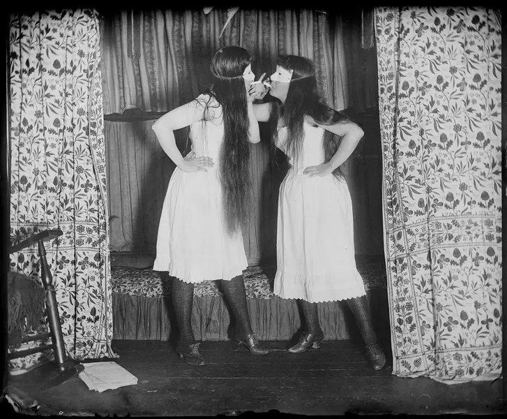 دو زن دوران ویکتوریایی که ماسک بر چهره دارند و به یکدیگر نگاه می‌کنند.