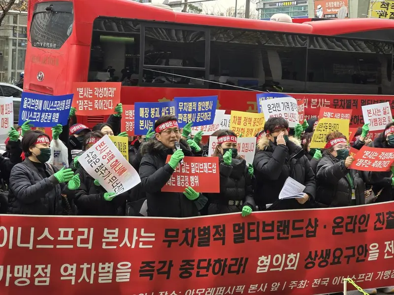 نمایندگان اینیسفری روز چهارشنبه در مقابل دفتر مرکزی آمورهپاسیک در منطقه یونگسان سئول اعتراض کردند و از شرکت درخواست کردند تا مزایای بازاریابی بیش از حد به کانالهای خرید چندبرند که محصولات اینیسفری را میفروشند، را قطع کند؛ این موضوع که به گفتهی آنها به فروشهای آفلاینشان آسیب میرساند. تصویر از اتحادیه نمایندگان اینیسفری