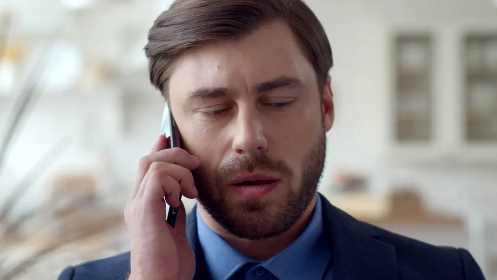 مردی که اضطراب تلفنی دارد و هنگام صحبت با تلفن مضطرب به نظر می‌رسد