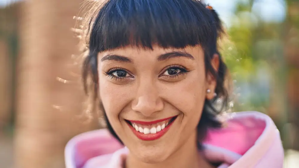 زنی واقعاً مهربان که در فضای باز لبخند میزند