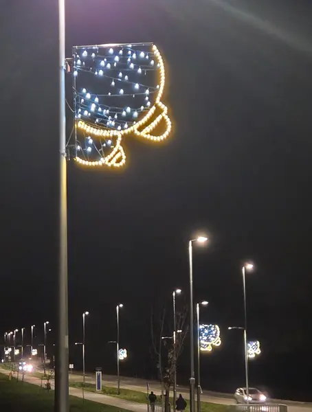 چراغهای خیابانی با زیورآلات درخشانی که جشنوارهای را نشان میدهند، در مسیر تاریک و آرام شب قرار دارند