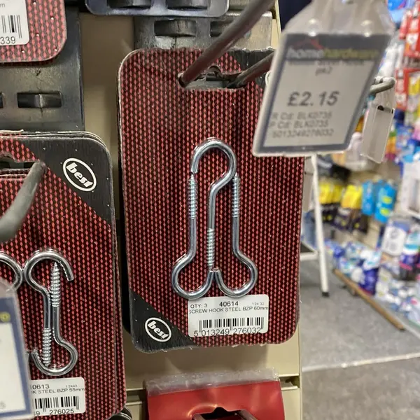 قفسهٔ فروشگاه سختافزار بستهای از قلابهای پیچدار به شکل نماد آلت تناسلی و برچسب قیمت £2.15 را نشان میدهد