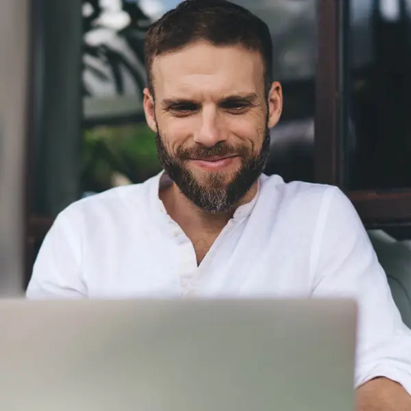 مردی که خود را بیش از حد توضیح نمی‌دهد در حال کار با لپ‌تاپ